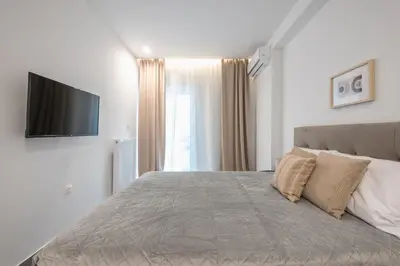 a bedroom with a bed and a flat screen tv at Minimal Harmony Apartment - Nea Smyrni by ΜΡS in Athens