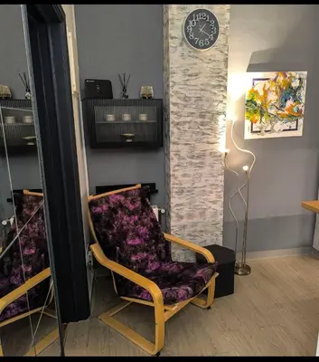 a room with a chair and a clock on a wall at Stylish Urban Studio στο Γουδί in Athens