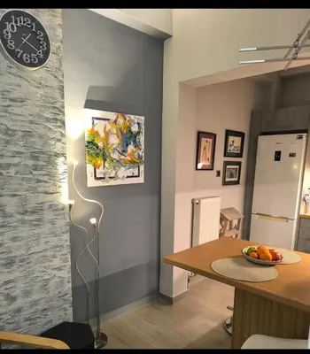 a dining room with a table and a wall at Stylish Urban Studio στο Γουδί in Athens