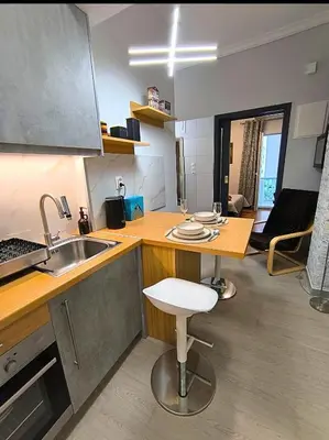a kitchen with a sink and a counter with a stool at Stylish Urban Studio στο Γουδί in Athens
