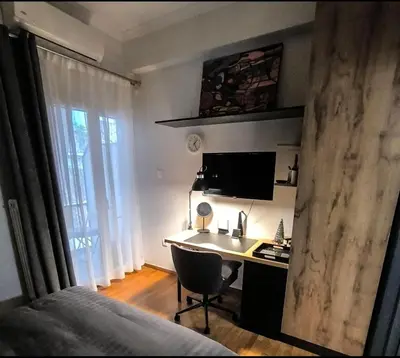 a bedroom with a desk and a bed and a room with a computer at Stylish Urban Studio στο Γουδί in Athens