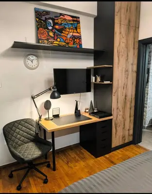 a desk with a monitor and a chair in a room at Stylish Urban Studio στο Γουδί in Athens