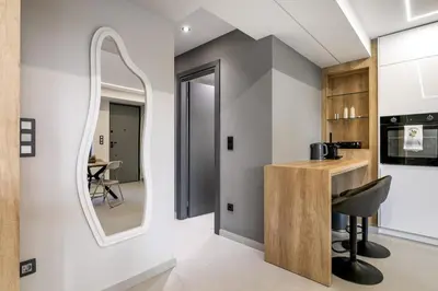 a kitchen with a mirror and a table with a chair at Clavé - Deluxe Studio in Athens in Athens