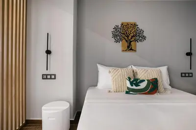 a bedroom with a bed with a tree on the wall at Clavé - Deluxe Studio in Athens in Athens