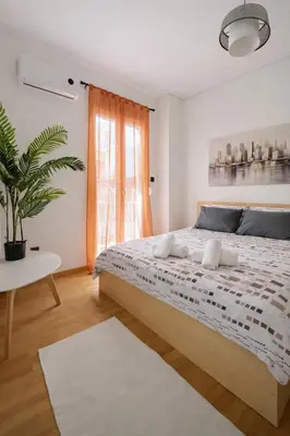 a bedroom with a large bed and a potted plant at Minimal Urban Apartment near Kolonaki in Athens
