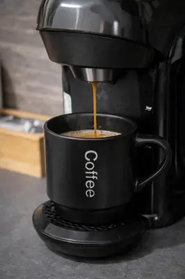 a coffee maker is making a cup of coffee at Minimal Urban Apartment near Kolonaki in Athens