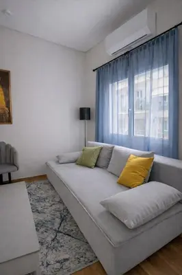 a living room with a couch and a window at Minimal Urban Apartment near Kolonaki in Athens