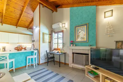 a living room with a tv and a fireplace at Iliachtida House in Sounio