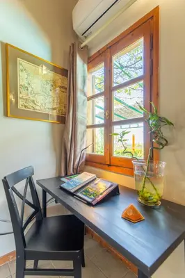 a blue desk with a chair and a window at Iliachtida House in Sounio