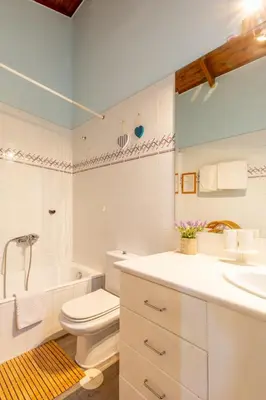 a bathroom with a toilet and a tub and a sink at Iliachtida House in Sounio