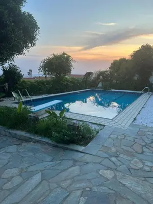 a swimming pool with a sunset in the background at ART BLUE RESIDENCE Pool in Aghia Marina