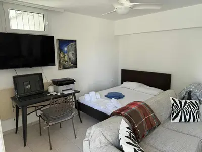 a living room with a couch and a tv at ART BLUE RESIDENCE Pool in Aghia Marina