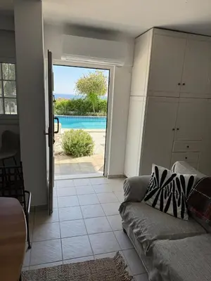 a living room with a couch and a view of a pool at ART BLUE RESIDENCE Pool in Aghia Marina