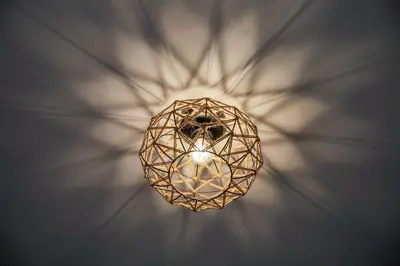 a chandelier hanging from a wall with rays of light at Bohemian Sunny apt Athens Center in Athens