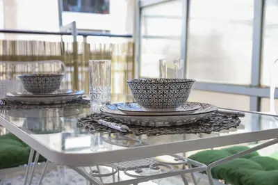 two bowls on a glass table with plates and glasses at Bohemian Sunny apt Athens Center in Athens
