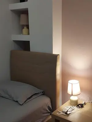 a bedroom with a bed and a table with a lamp at Gousa Urban Stay 2 Min Walk to Metro in Athens