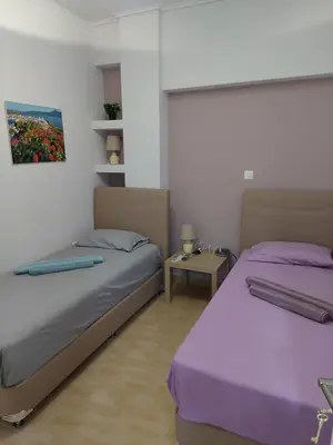 a bedroom with two beds and a table at Gousa Urban Stay 2 Min Walk to Metro in Athens