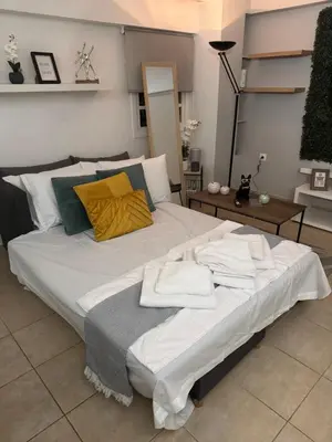 a large bed with towels on it in a room at Aiolos cozy GLYFADA near the centre in Athens