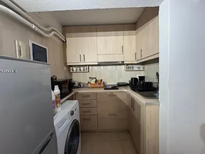 a kitchen with wooden cabinets and a washer and dryer at Aiolos cozy GLYFADA near the centre in Athens