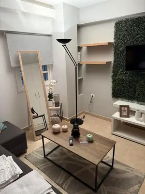a living room with a table and a lamp at Aiolos cozy GLYFADA near the centre in Athens