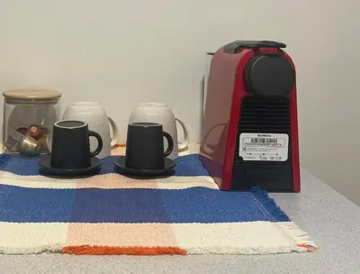 a toaster and three coffee cups on a towel at Κομψό Διαμέρισμα στο Πασαλιμάνι in Piraeus