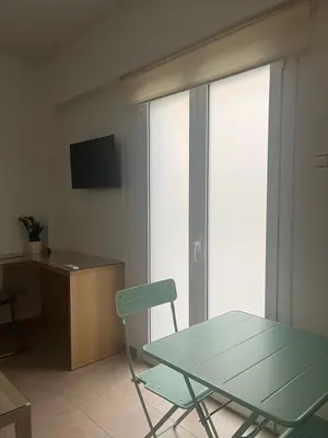 a room with a table and a chair and a desk at Κομψό Διαμέρισμα στο Πασαλιμάνι in Piraeus