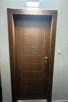 a brown door in a room with a light at Κομψό Διαμέρισμα στο Πασαλιμάνι in Piraeus