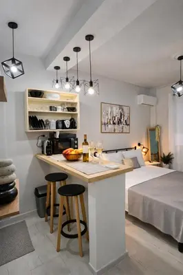 a room with a bed and a kitchen with a counter at Cozy Estia in Athens