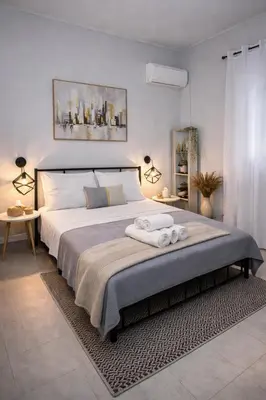 a bedroom with a large bed with two towels on it at Cozy Estia in Athens