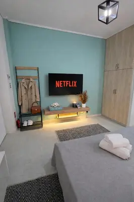 a bedroom with a netflix sign on the wall at Cozy Estia in Athens