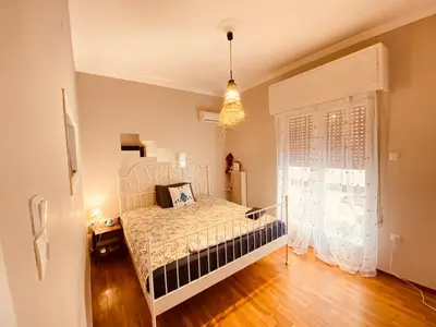 a bedroom with a bed and a large window at Cosy full apartment in Athens