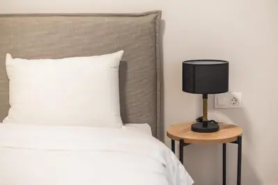 a bed with a black lamp on a side table at Zografou Urban Apartments, A2Zen in Athens
