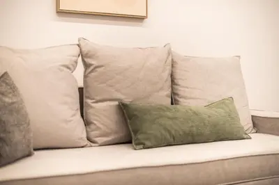 a couch with four pillows on top of it at Zografou Urban Apartments, A2Zen in Athens