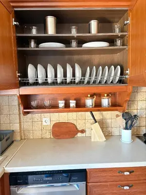 a kitchen counter with plates and utensils on a shelf at Purerest Entire Private Villa in Athens