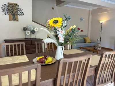 a dining room with a table with a vase of flowers at Purerest Entire Private Villa in Athens