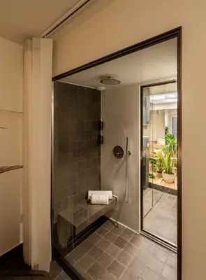 a bathroom with a shower with a glass door at ERE Acropolis Courtyard in Athens