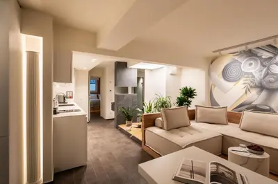 a living room with a couch and a kitchen at ERE Acropolis Courtyard in Athens