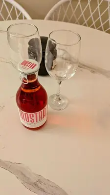 two wine glasses and a bottle of sauce on a table at Arhontoula Single-Family 2 Bedroom Home Kalithea in Athens