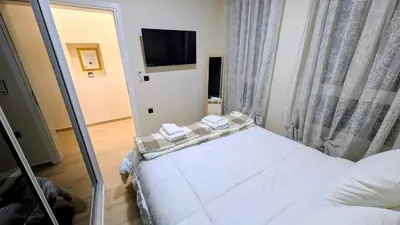 a bedroom with a white bed and a television at Arhontoula Single-Family 2 Bedroom Home Kalithea in Athens