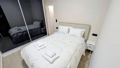 a bedroom with a white bed with a mirror at Arhontoula Single-Family 2 Bedroom Home Kalithea in Athens