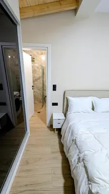 a bedroom with a large white bed and a mirror at Arhontoula Single-Family 2 Bedroom Home Kalithea in Athens