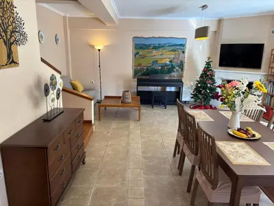 a living room with a dining table and a christmas tree at Purerest villa room A en suite in Athens