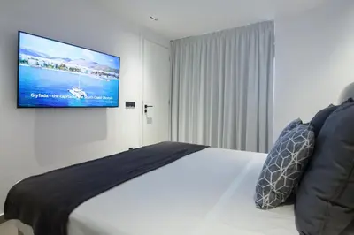 a bedroom with a bed with a tv on the wall at Penthouse in the Heart of Glyfada in Athens