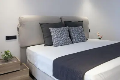 a bed with two pillows on it in a bedroom at Penthouse in the Heart of Glyfada in Athens