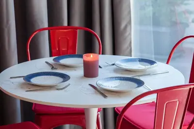 a white table with plates and a candle on it at Penthouse in the Heart of Glyfada in Athens