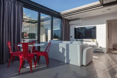 a dining room with red chairs and a table at Penthouse in the Heart of Glyfada in Athens