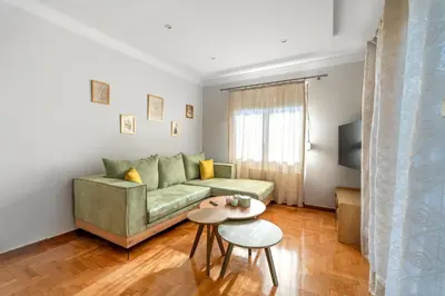 a living room with a green couch and a table at Zeas Yacht View in Piraeus