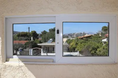 a window with a view of a city at DAT Comfy house in Kalívia Thorikoú