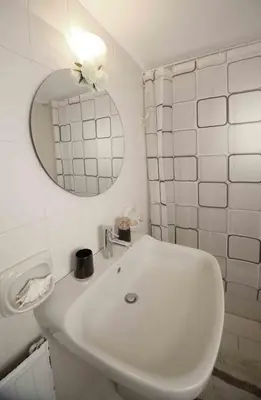 a white bathroom with a sink and a mirror at DAT Comfy house in Kalívia Thorikoú