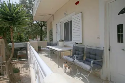 a dog is standing on the balcony of a house at DAT Comfy house in Kalívia Thorikoú